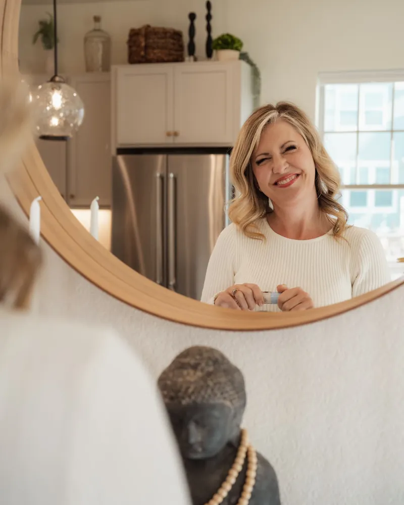 Brandy Unruh, REALTOR® with Compass, Erie, Colorado, reflected in a mirror in a staged kitchen