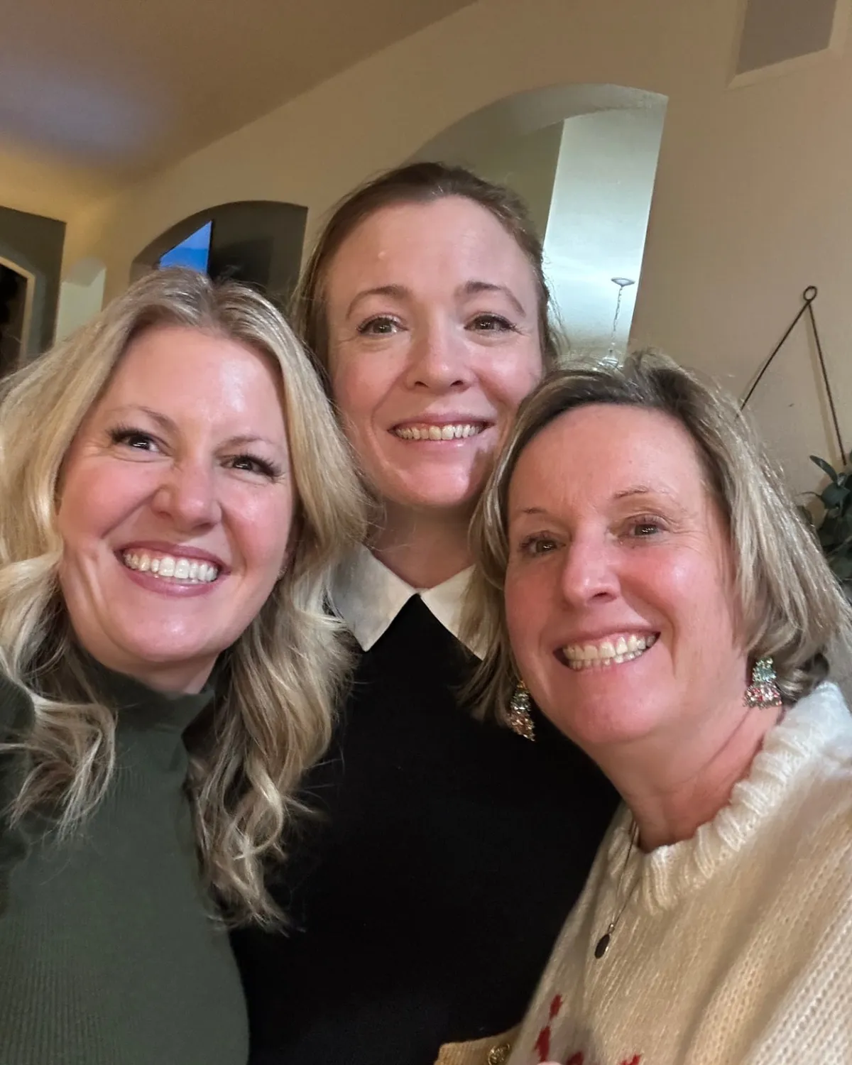 Brandy Unruh, REALTOR® with Compass, sharing a hug with happy clients in Colorado