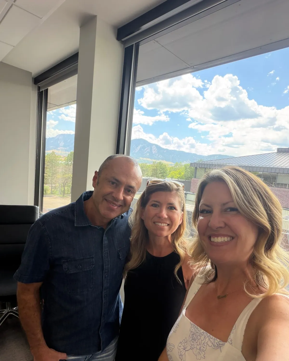 Brandy Unruh, REALTOR® with Compass, with clients at a Boulder County closing with Flatirons views
