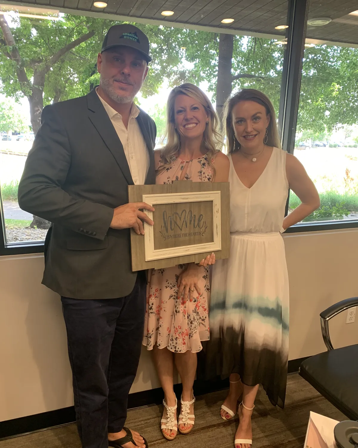 Brandy Unruh, REALTOR® with Compass, with clients holding a housewarming gift in Colorado