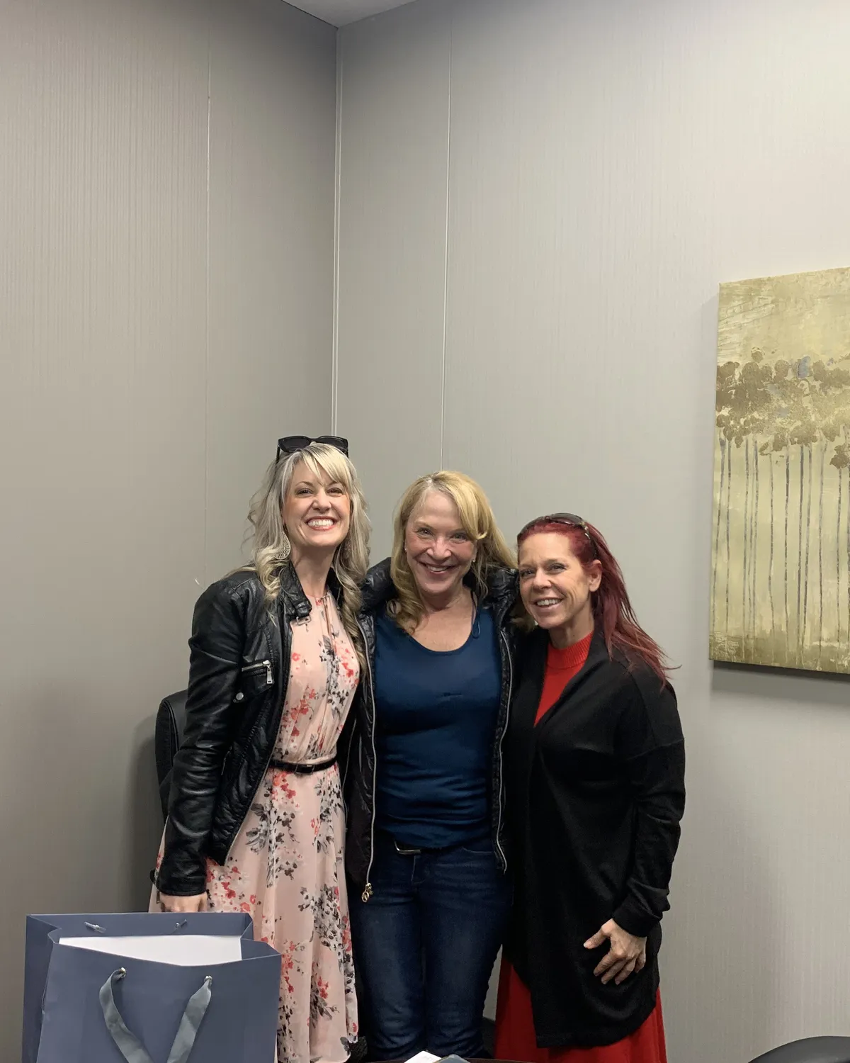 Brandy Unruh, REALTOR® with Compass, smiling with clients at a closing office in Colorado